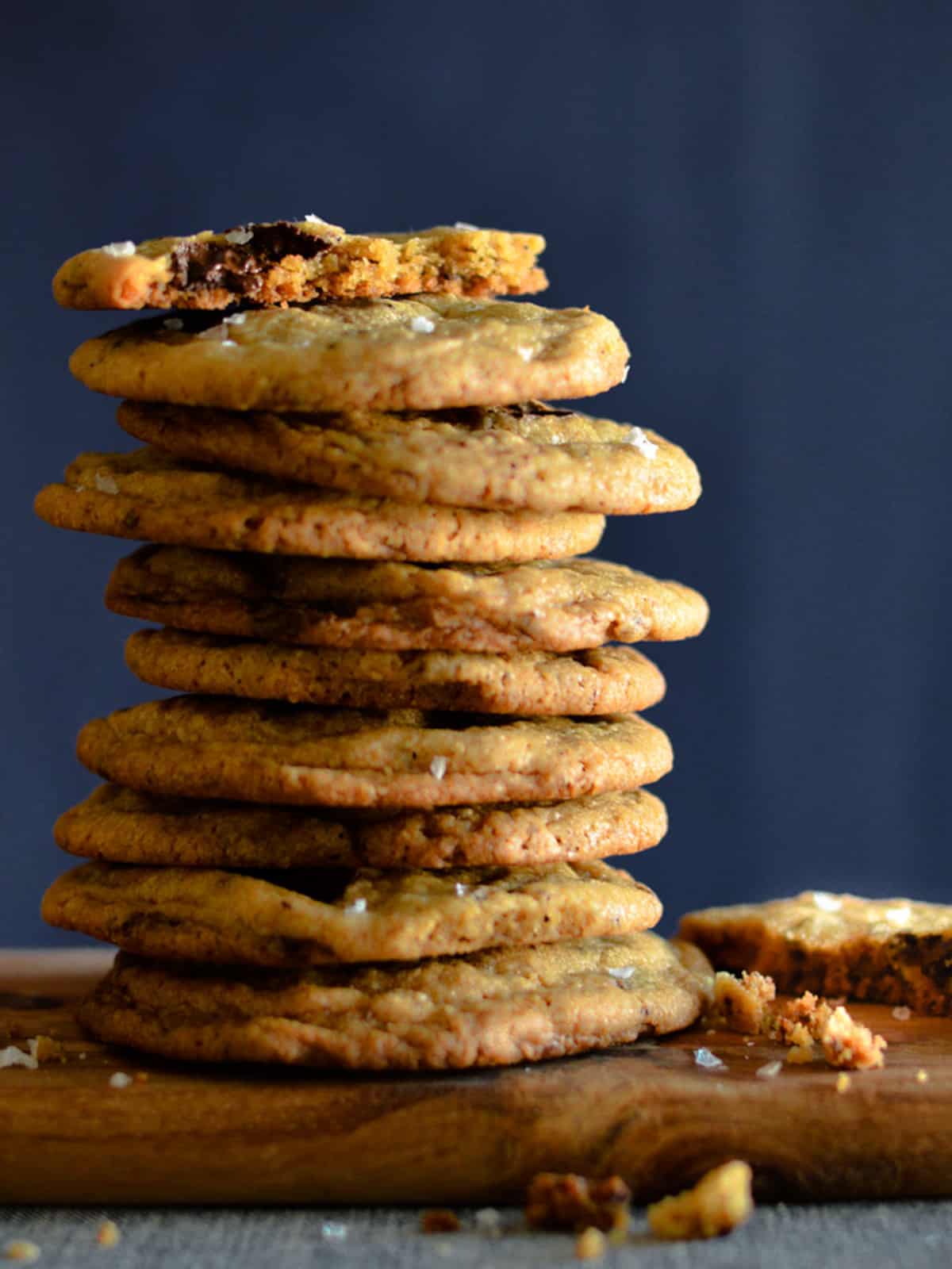 a stack of chocolate chip cookies. The top one has a bite out of it. 