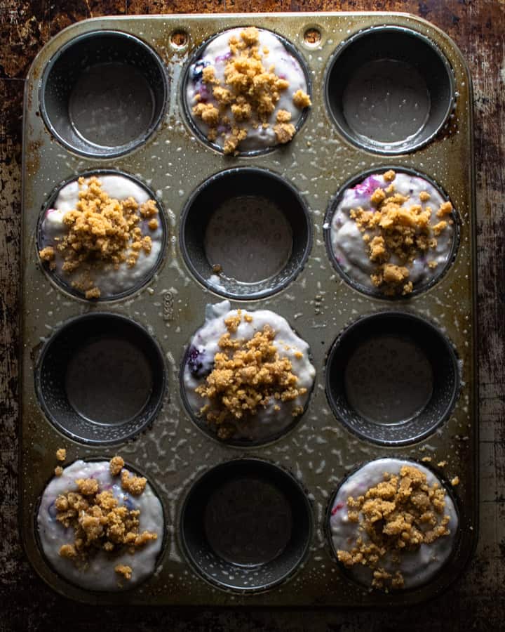 Unbaked muffin mix in pan with streusel before baking