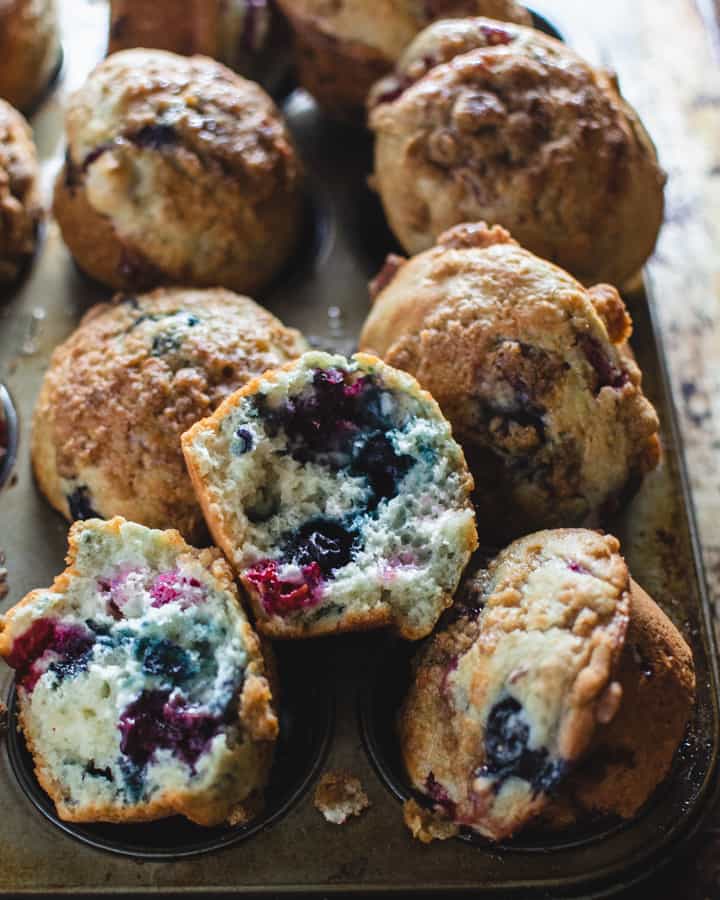 Close up of baked mixed berry muffins pulled apart to show inside