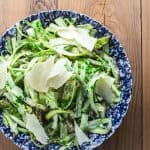 Creamy shaved asparagus salad with creamy Parmesan dressing on a blue plate