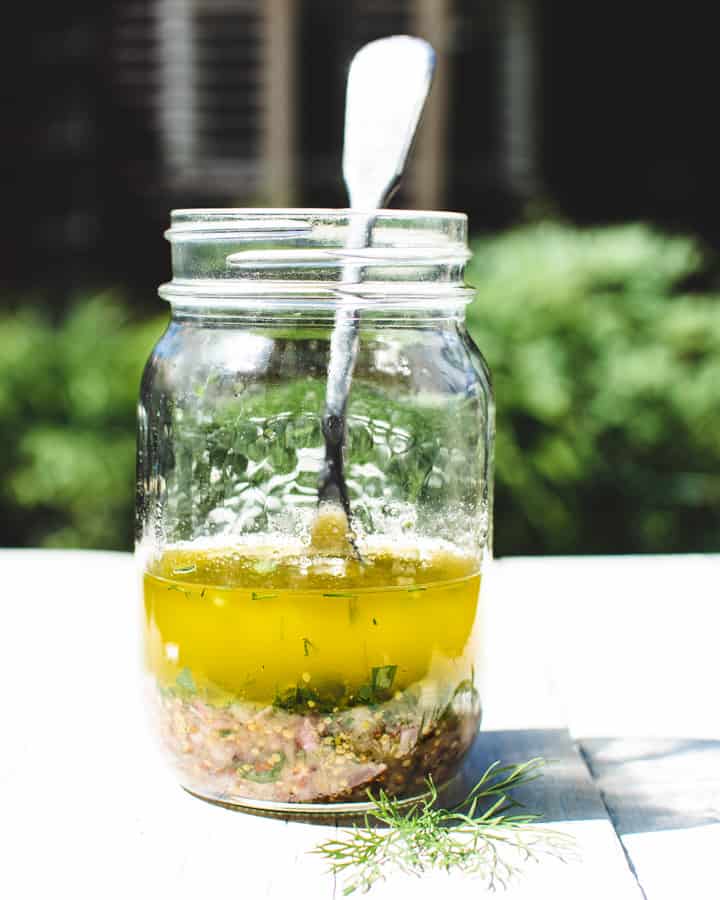 Mason jar with vinaigrette for Nicoise salad and fork.