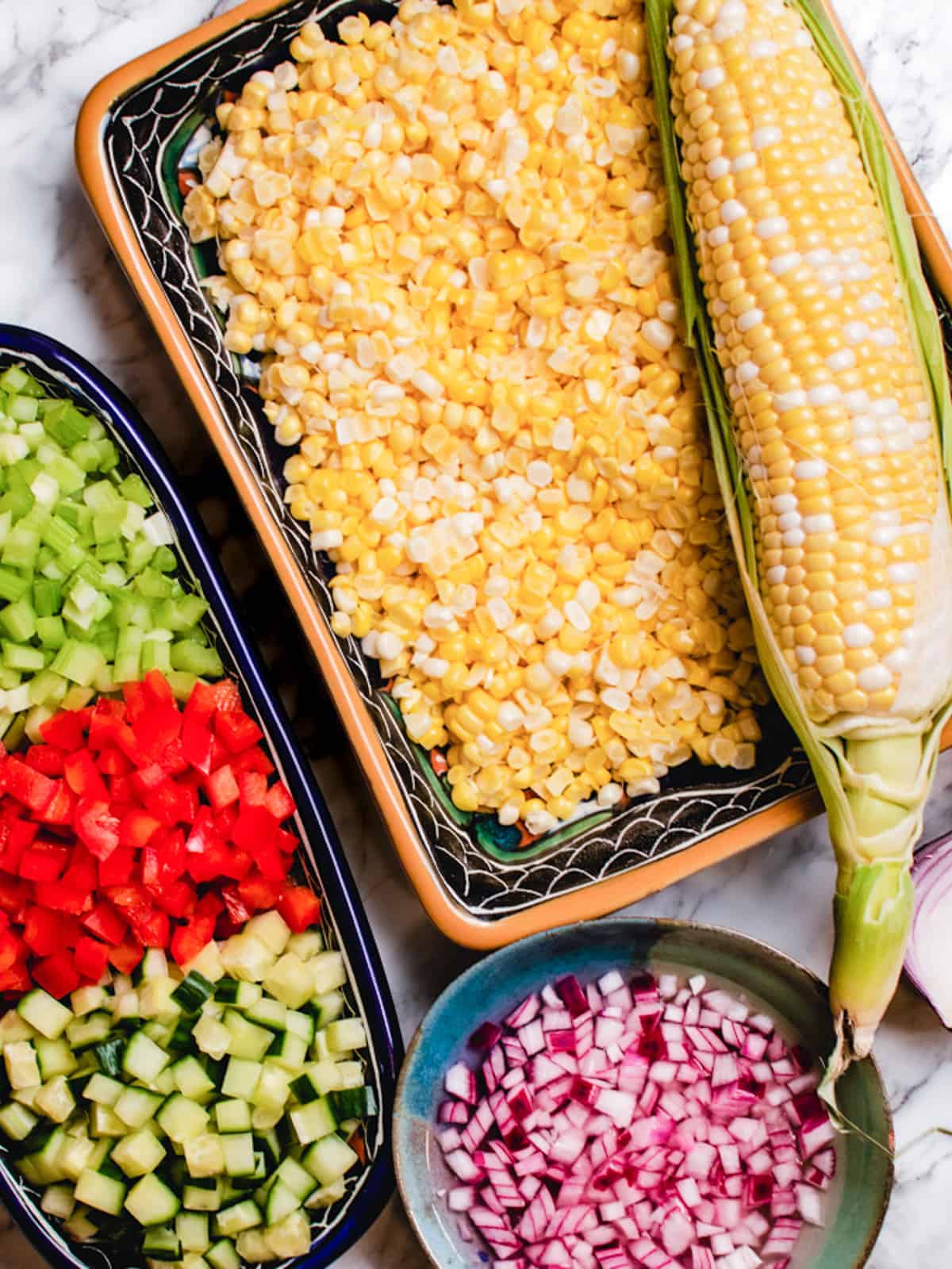 Prepared vegetables for corn salad plus one whole ear of corn.