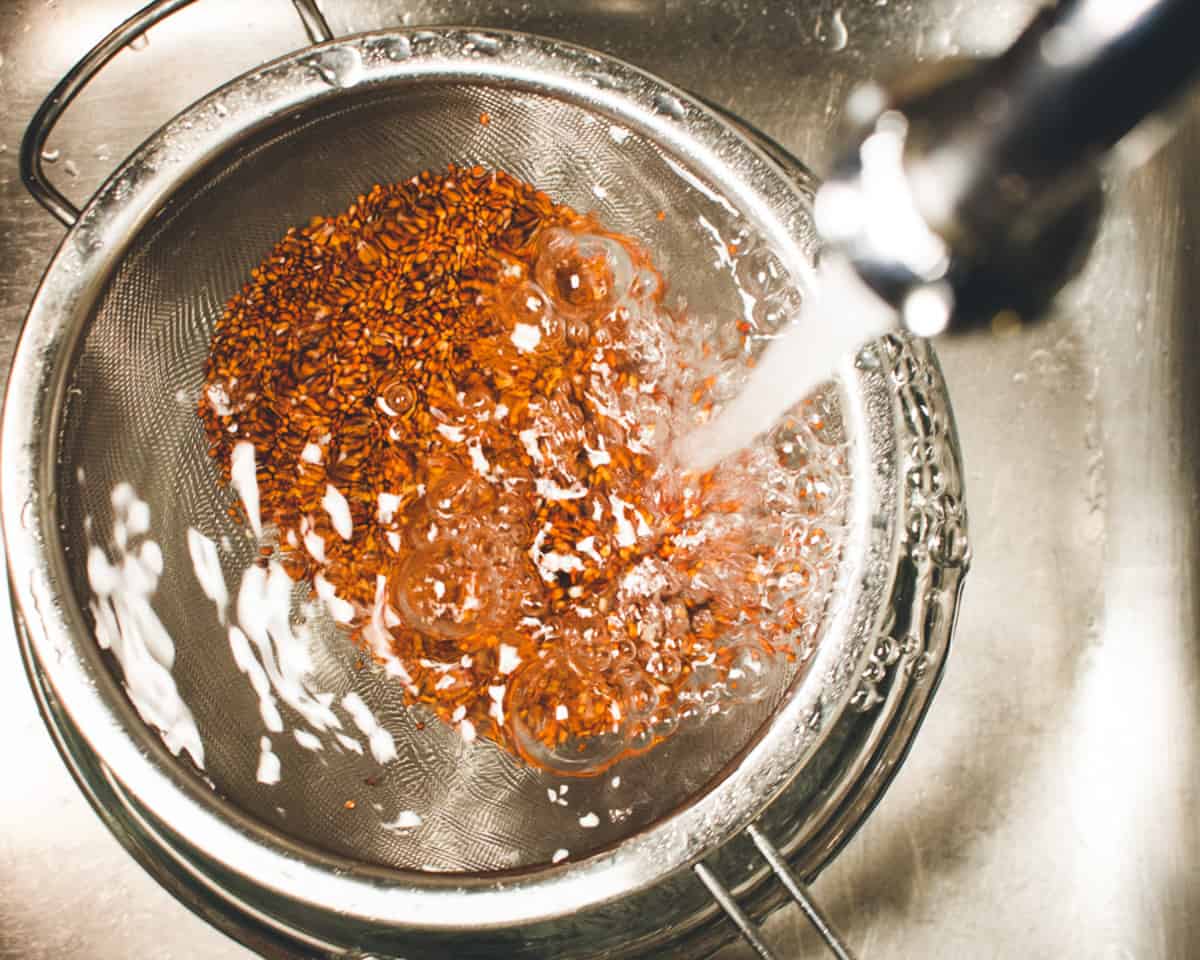 quinoa being rinsed in a seive.