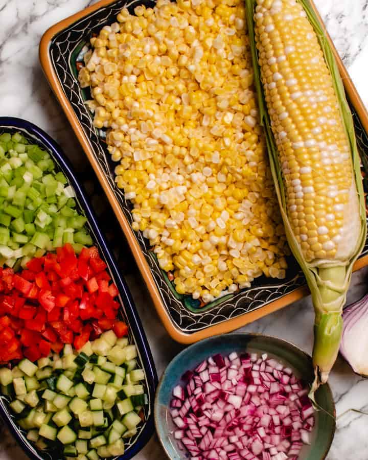 Prepared vegetables for corn salad plus one whole ear of corn