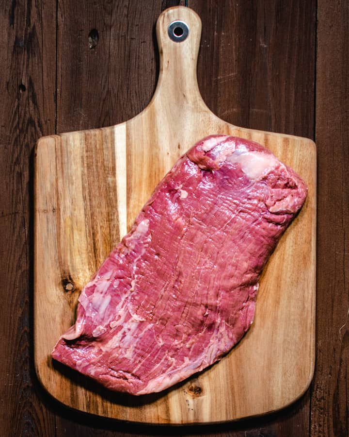 flank steak before marinating on a cutting board