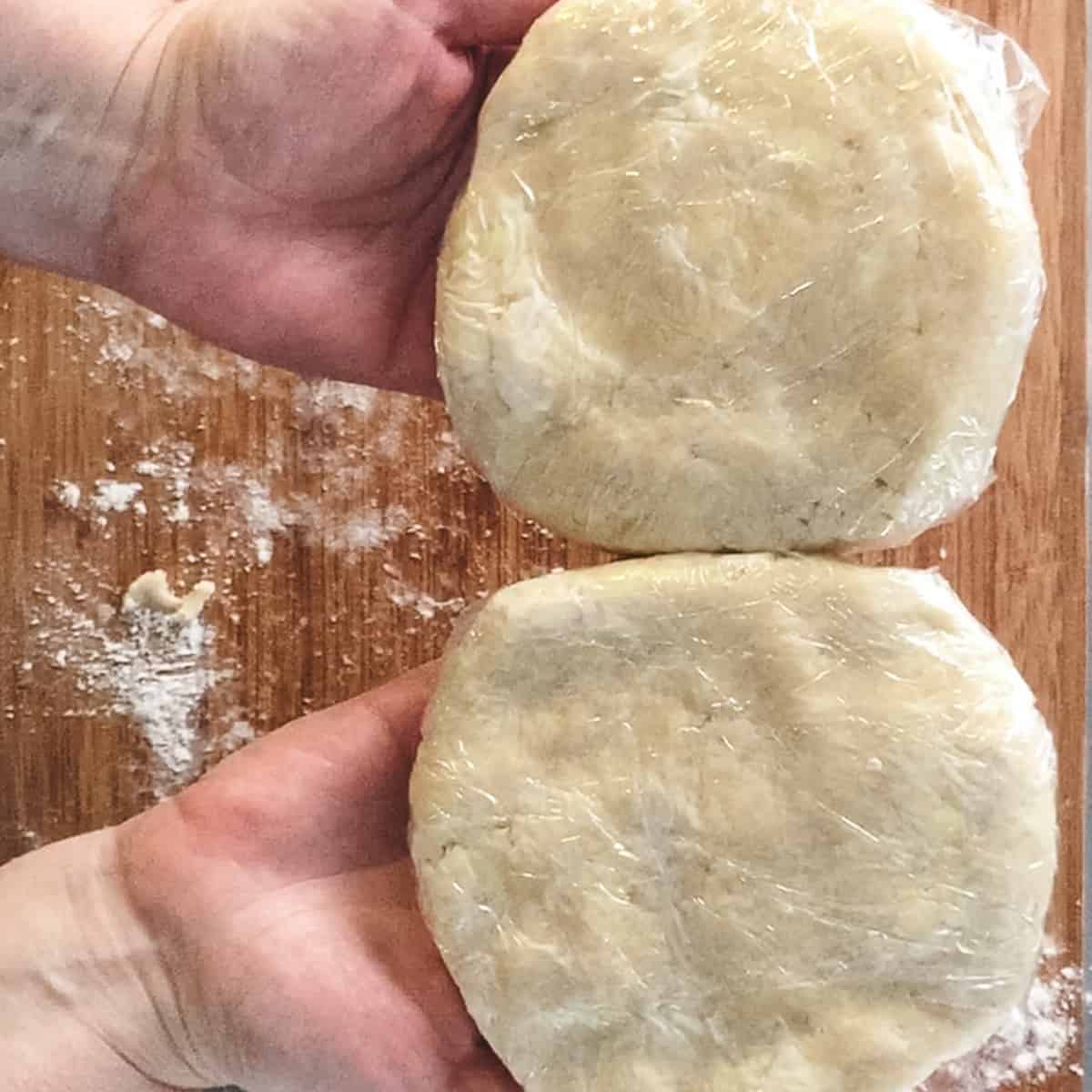 two disks of dough wrapped in plastic wrap.