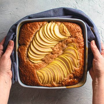 baked apple caramel pudding cake held in hands