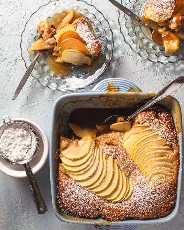 Apple caramel pudding cake after baking with one serving on side plate.