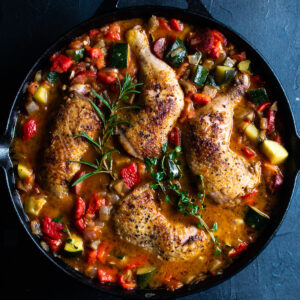 Spanish chicken bake in cast iron pan with mixed vegetables