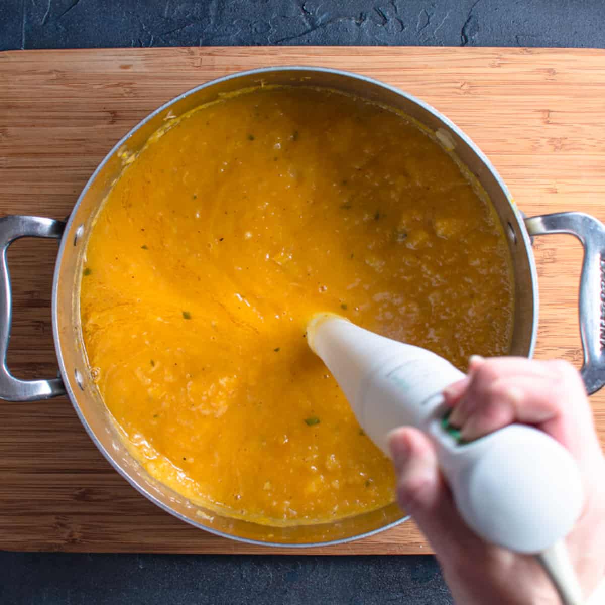 an immersion blender in a pot of soup. 