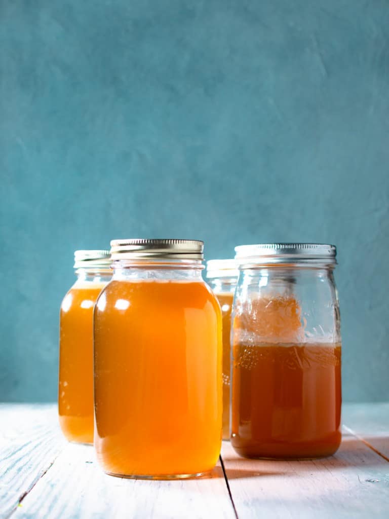 4 mason jars of homemade chicken stock