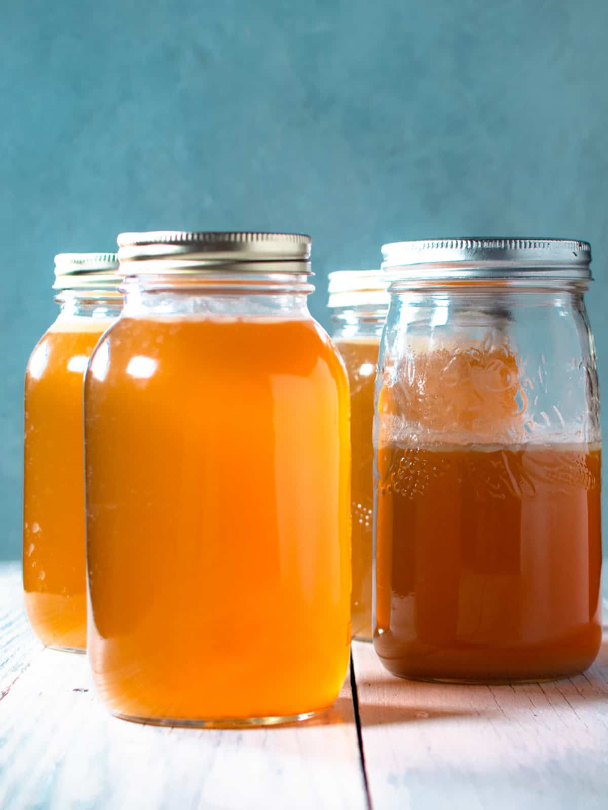 4 mason jars of homemade chicken stock.