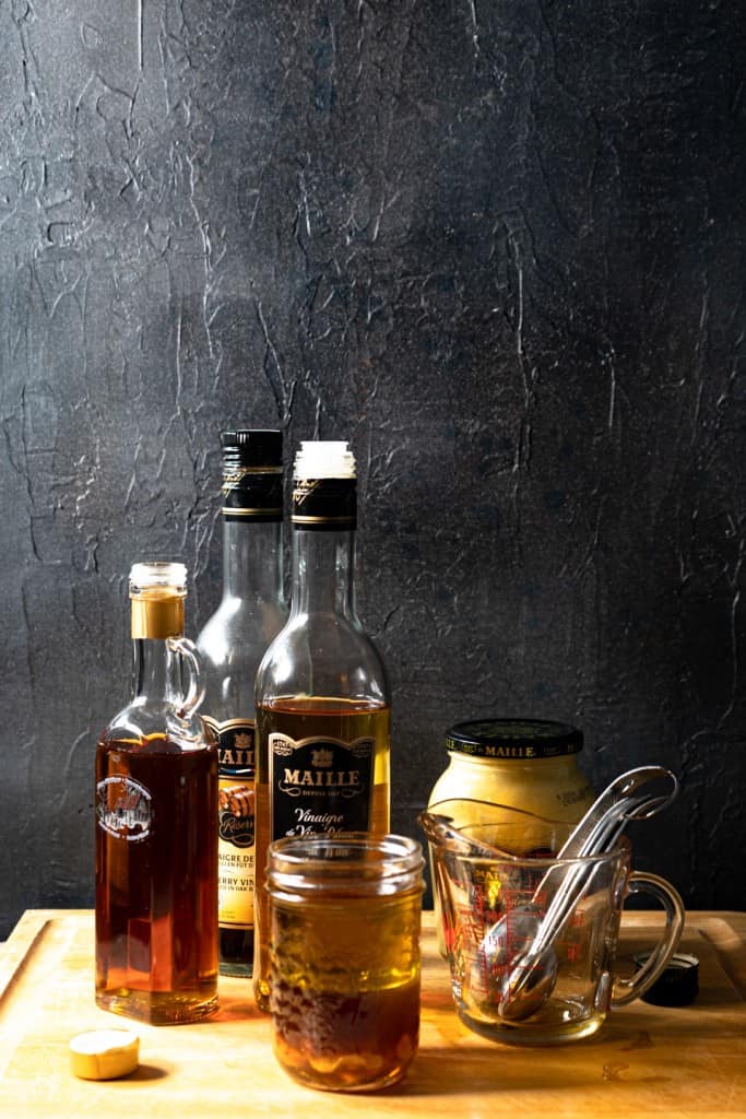 ingredients for maple dijon vinaigrette on wood board
