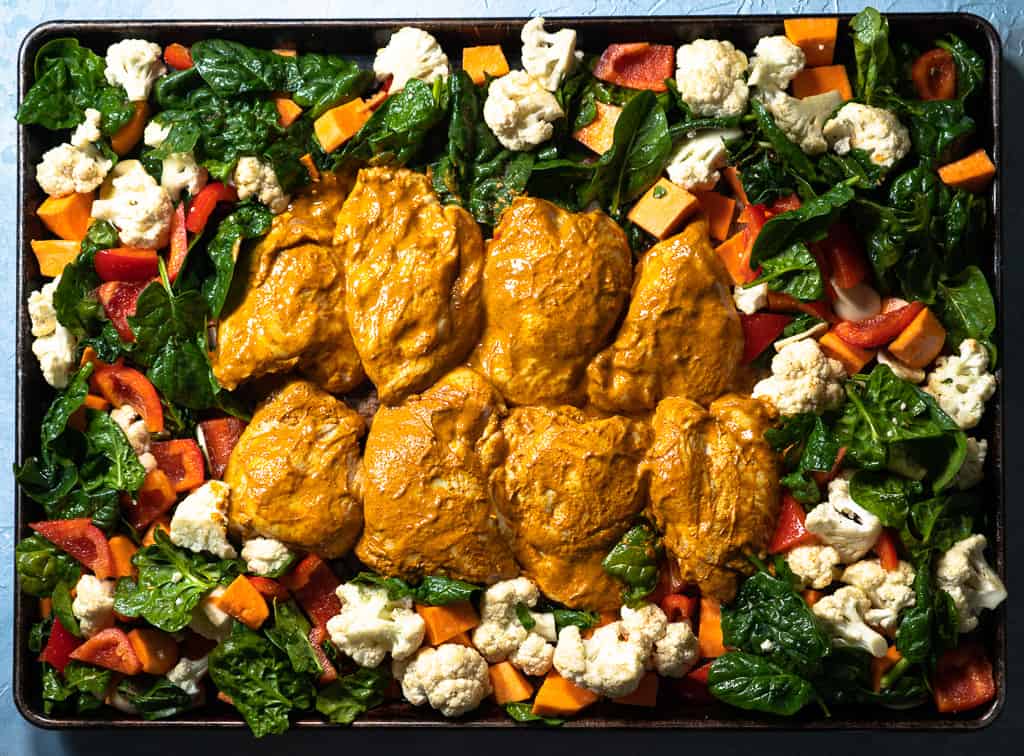 sheet pan curried chicken and vegetables on tray before baking