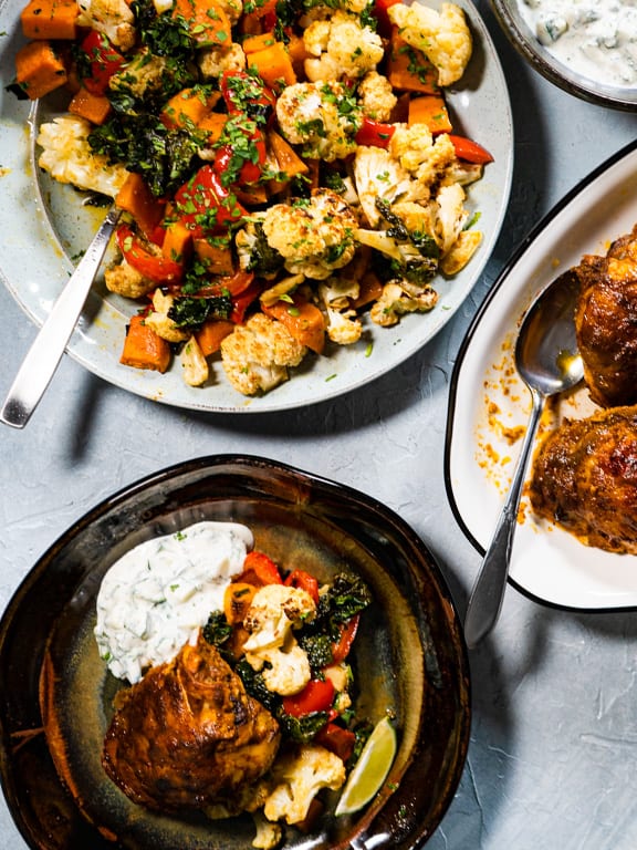 curried chicken thighs, roasted vegetables, raita and one serving of each on separate plates