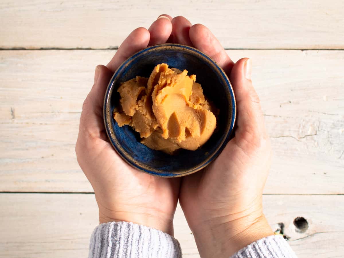 small blue bowl of miso paste held in hands