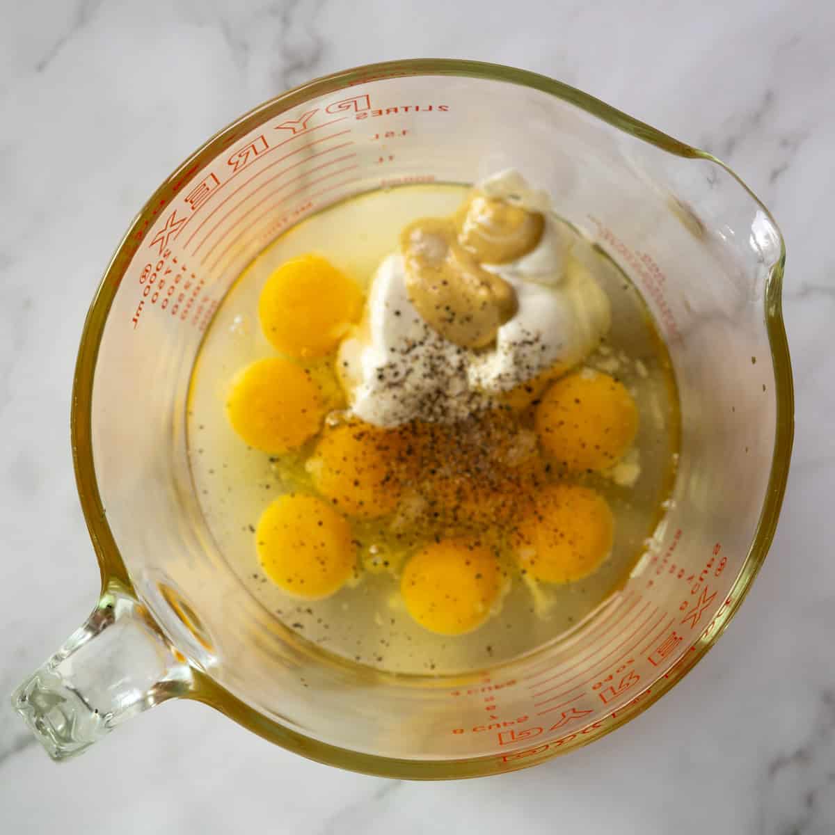 eggs, yogurt and Dijon in a bowl ready to be whisked.