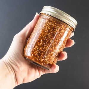 sesame soy dressing in a mason jar held in hand