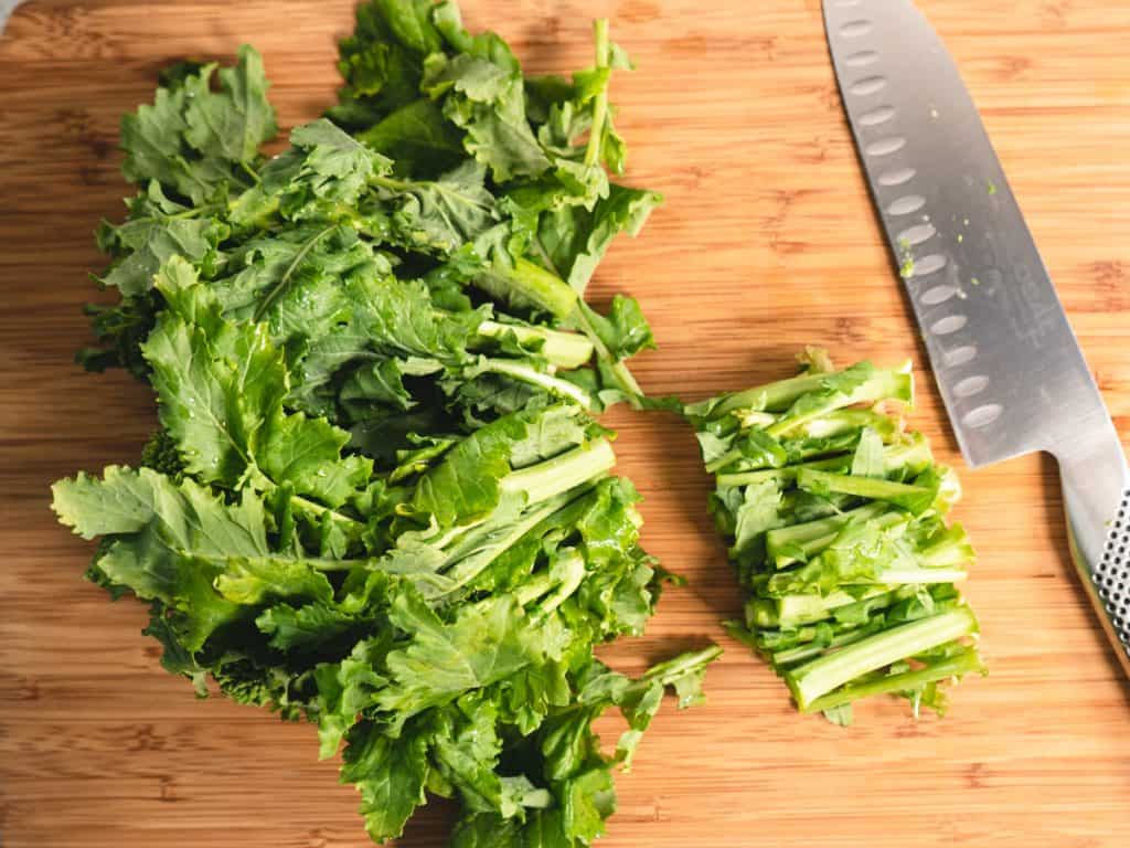 broccoli rabe with ends trimmed on a cutting board