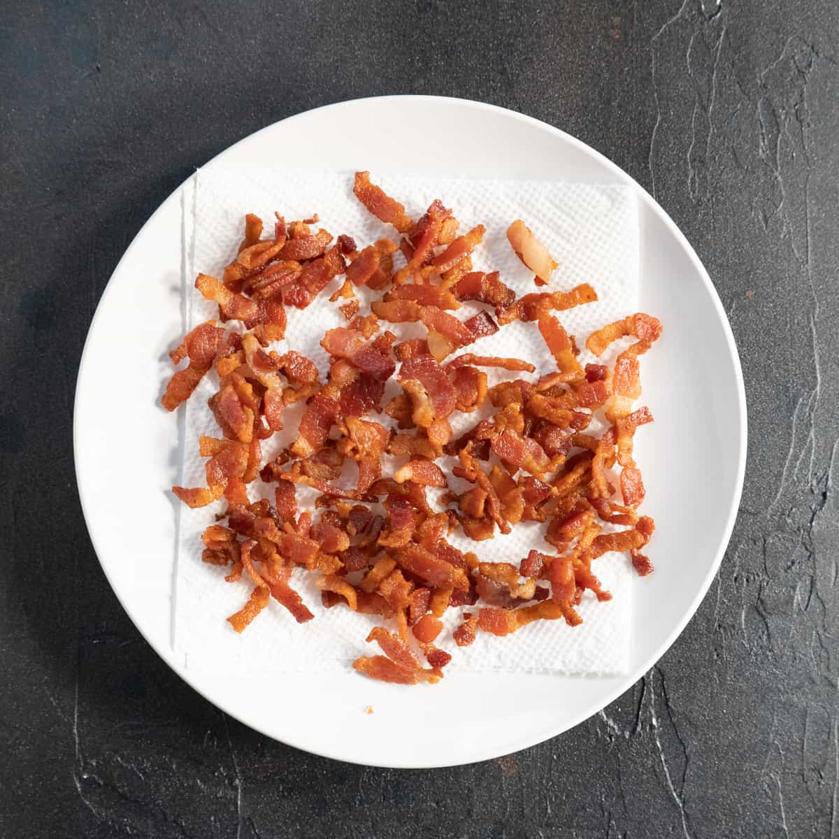 crispy cooked bacon on a white plate.