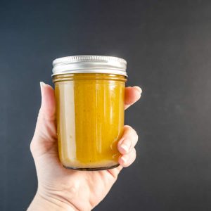 jar of cumin lime dressing with black background