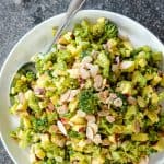 Roasted Broccoli salad on white plate with spoon on stone background