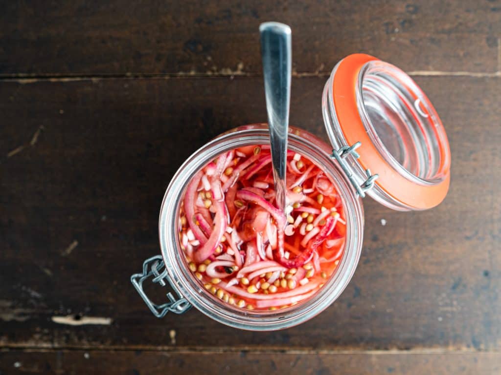 pickled onions in a jar with spoon