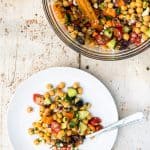 single serving of greek chickpea salad on white plate with fork
