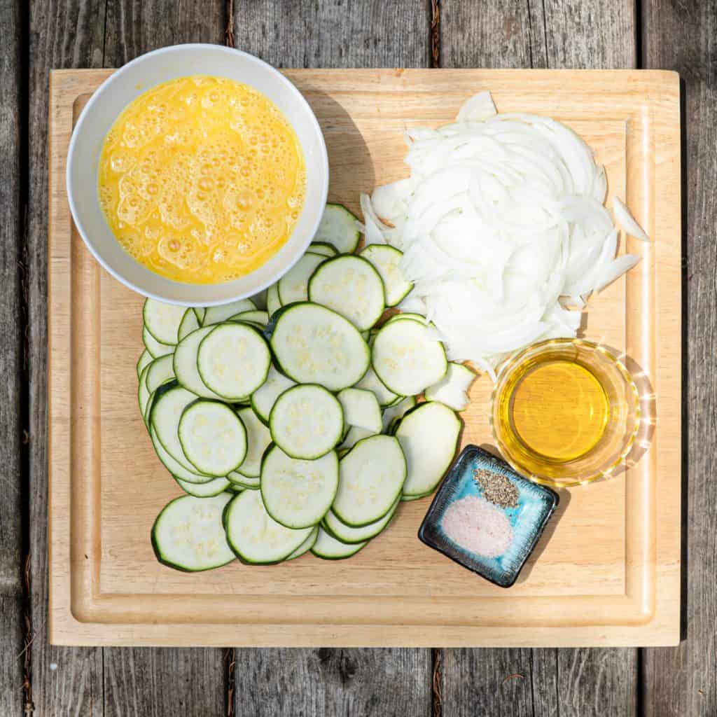 prepared ingredients for omelette on a wood board