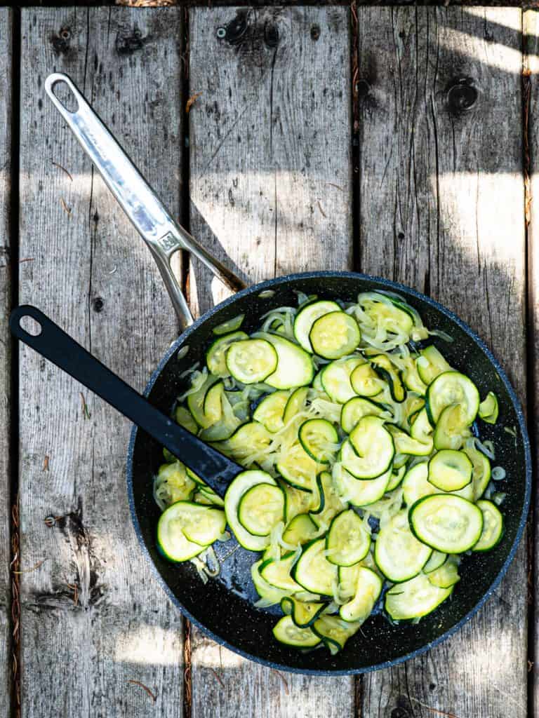 Cooked zucchini and onions in frying pan