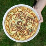 A whole zucchini omelet on a white plate.
