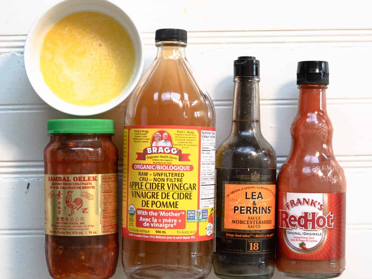melted butter, sambal, apple cider vinegar, Worcestershire sauce and franks red hot sauce shown in their bottles