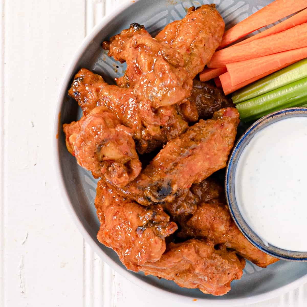 chicken wings on a plate with carrot and celery sticks and blue cheese dip