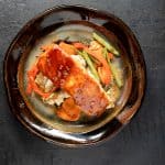 Salmon and vegetables on brown pottery plate