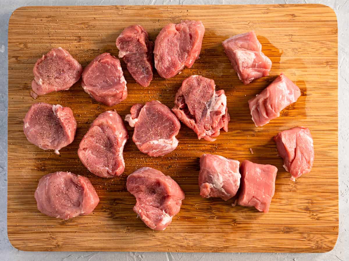 seasoned pork medallions on a wood board