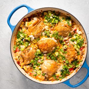 Finished Tex Mex Chicken Bake in blue casserole dish. Garnished with green onions and cilantro