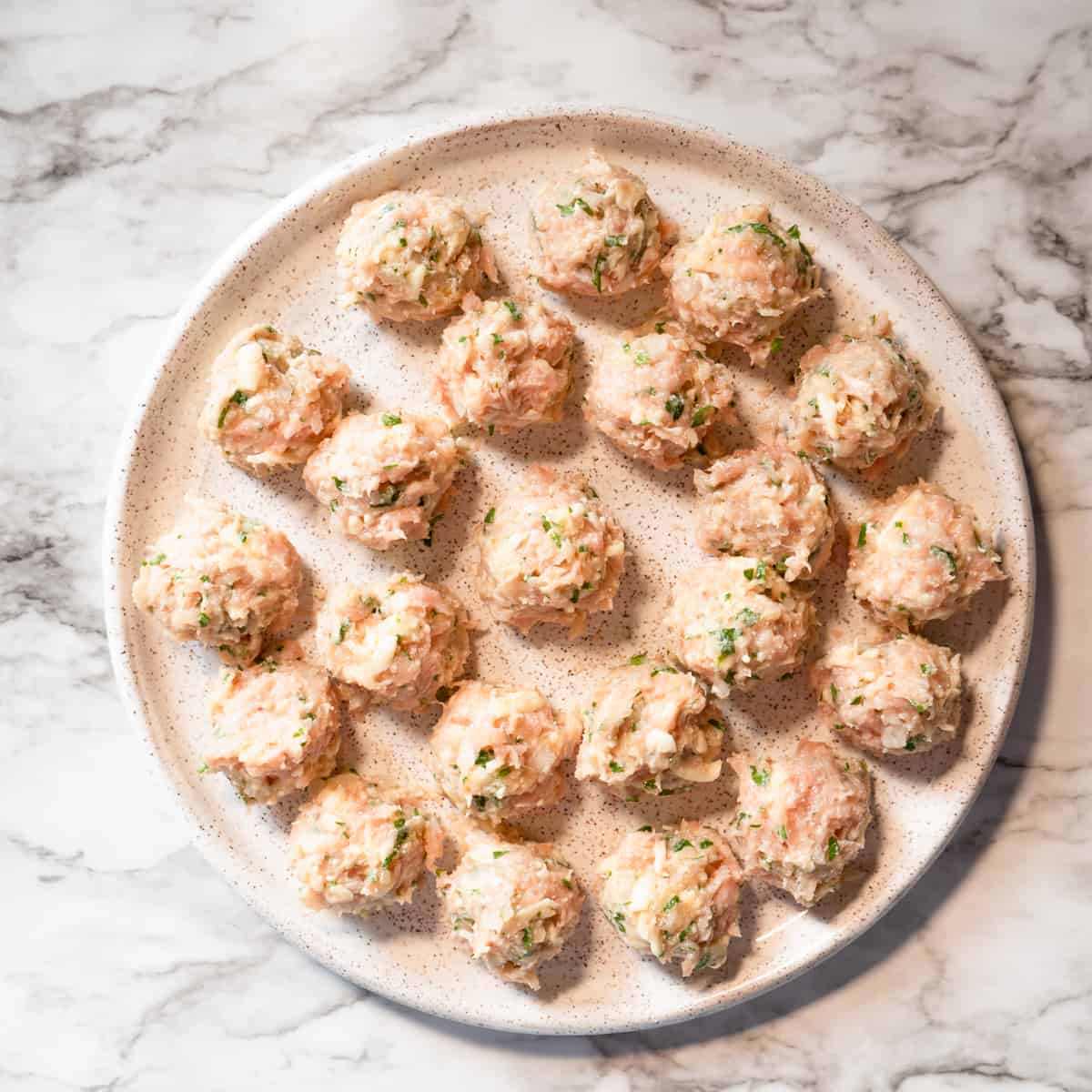 22 formed meatballs on a ceramic plate