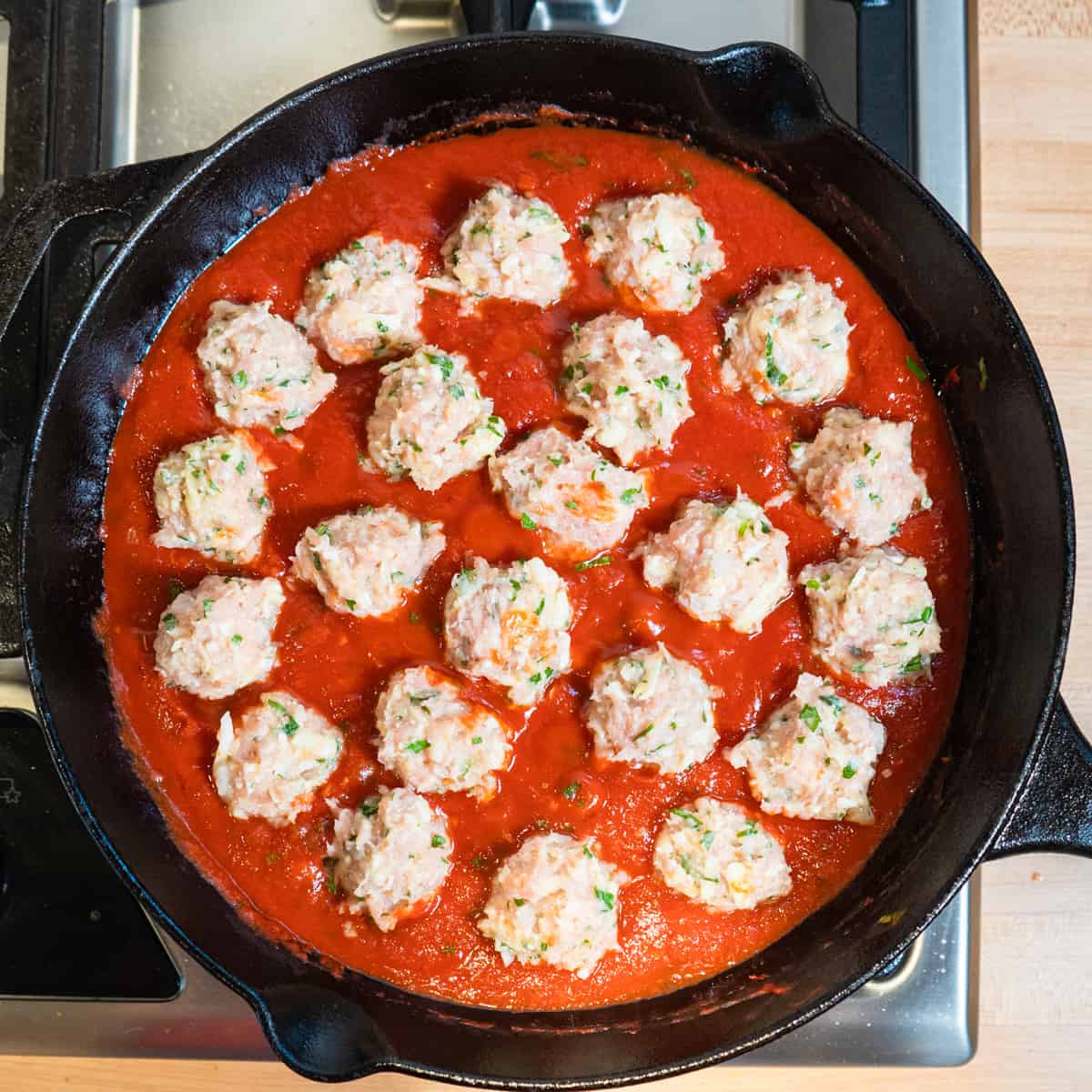 meatballs are added to the sauce in the skillet
