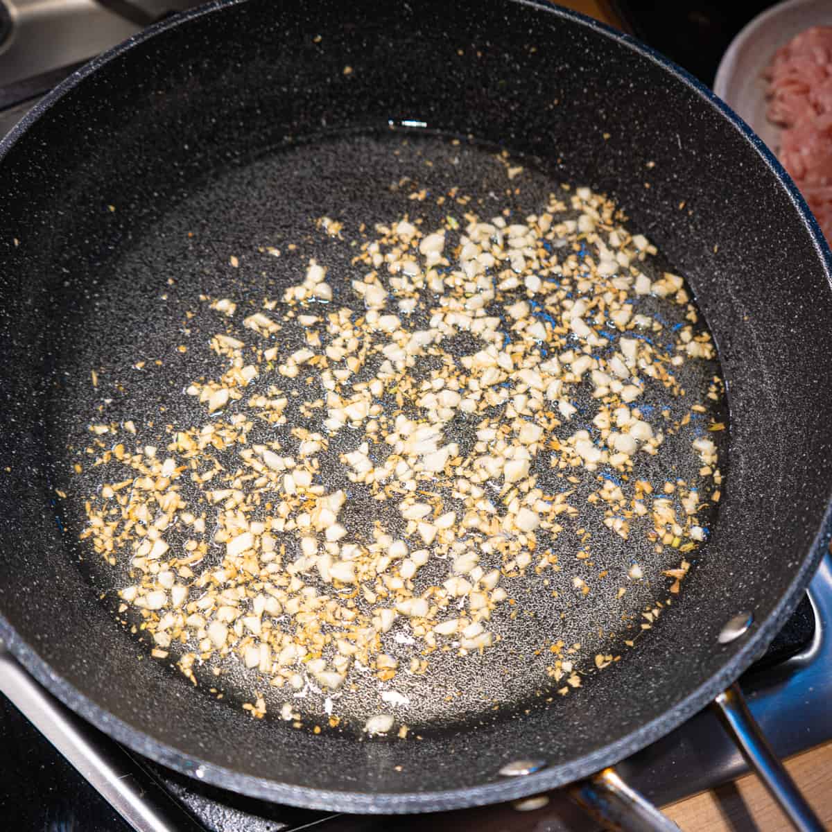 garlic starting to brown in a frying pan