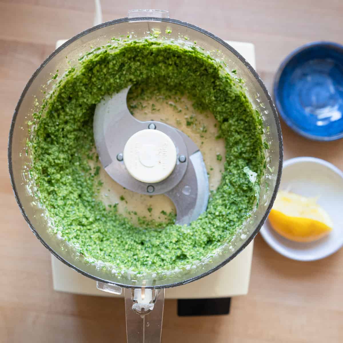 Pesto in the bowl of a food processor after being pureed.