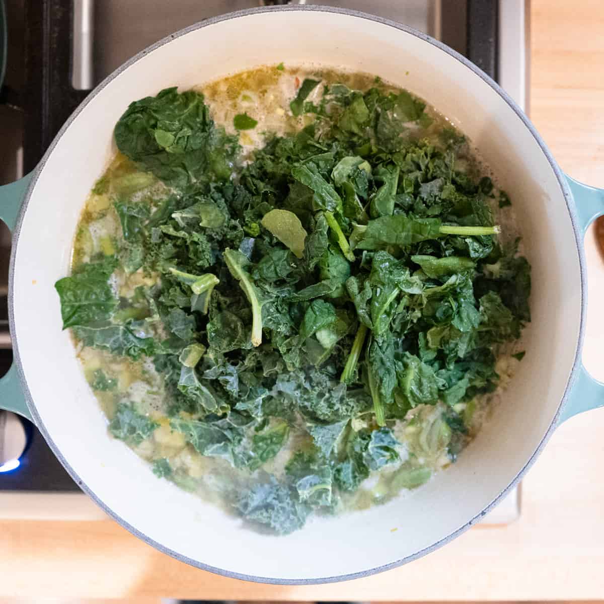 Step 4. Kale is added to the pot. 