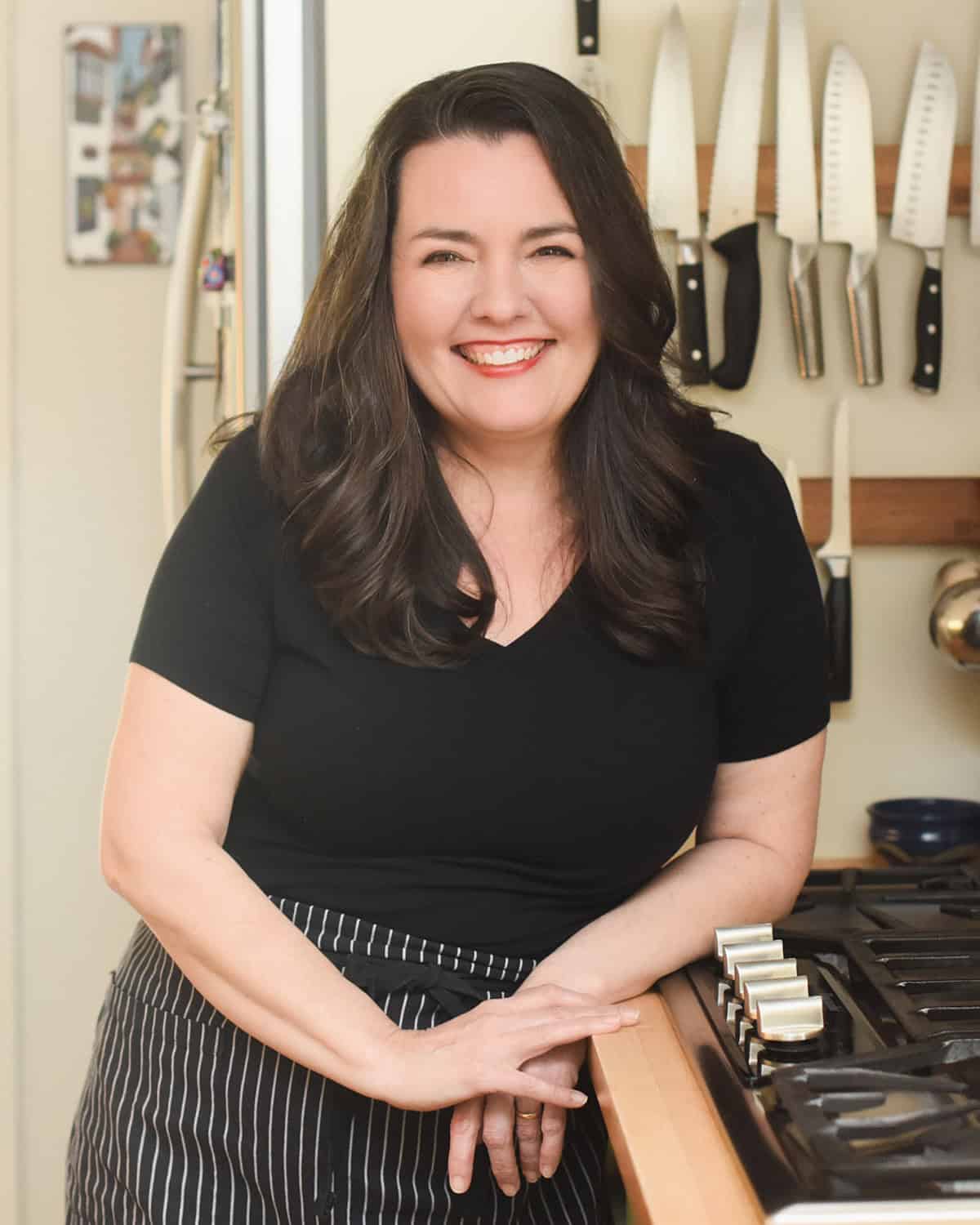 portrait of Andrea Mut standing in her kitchen.