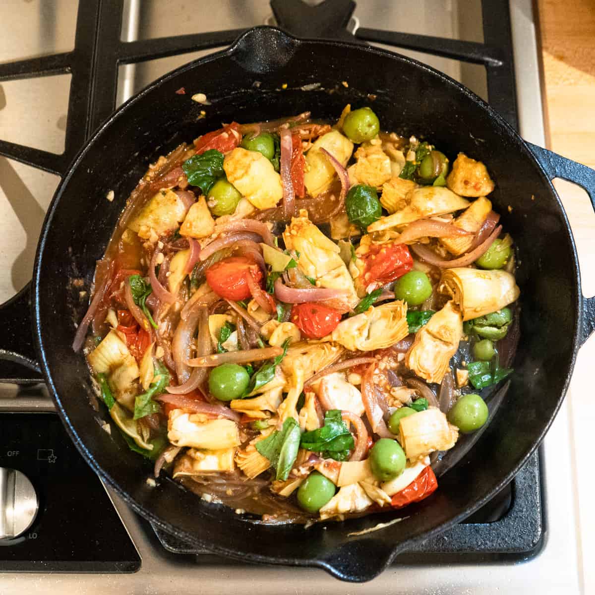 Vegetables cooking in a cast iron skillet.