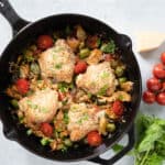 cast iron pan with finished chicken and artichoke dish