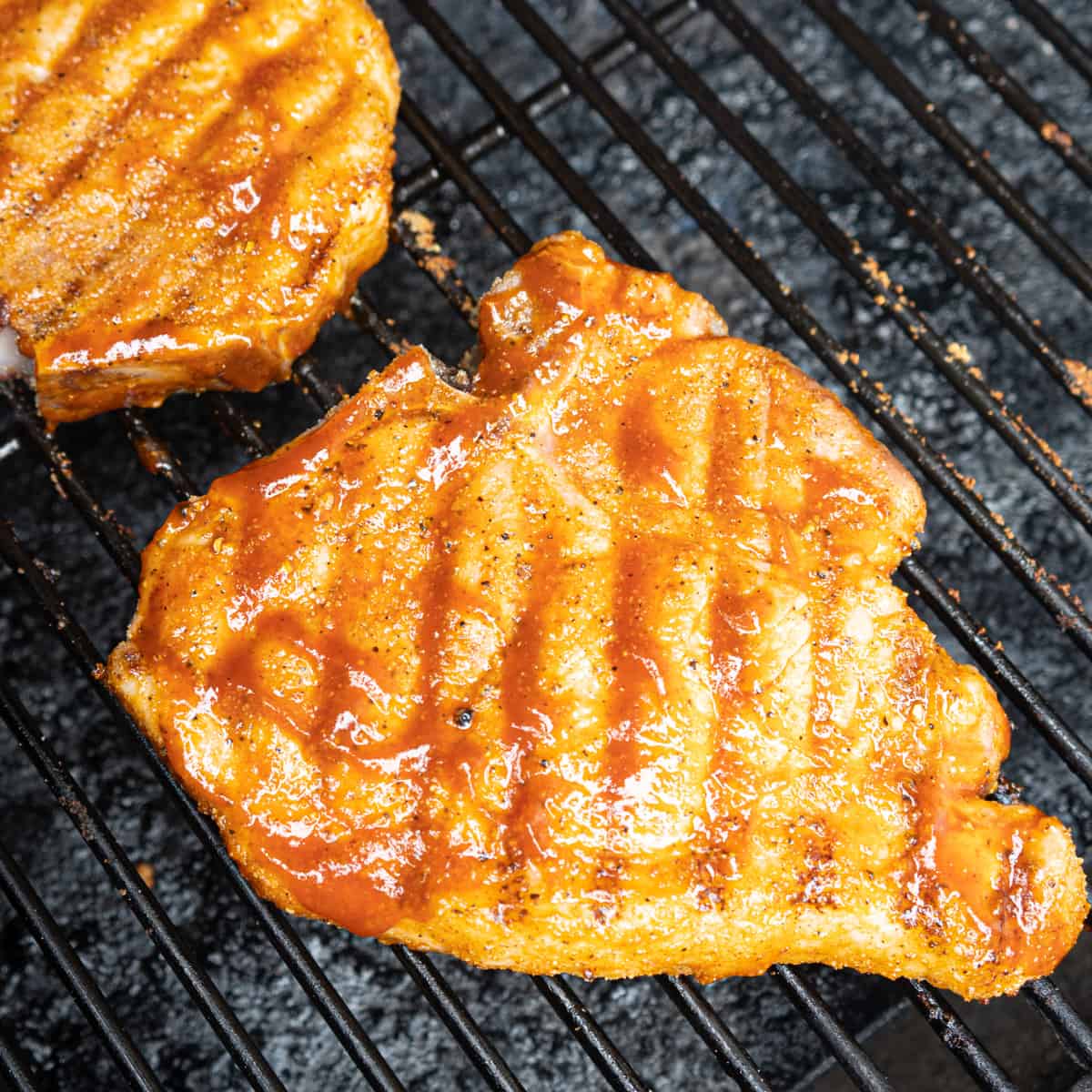 Pork chops cooking on the grill. 