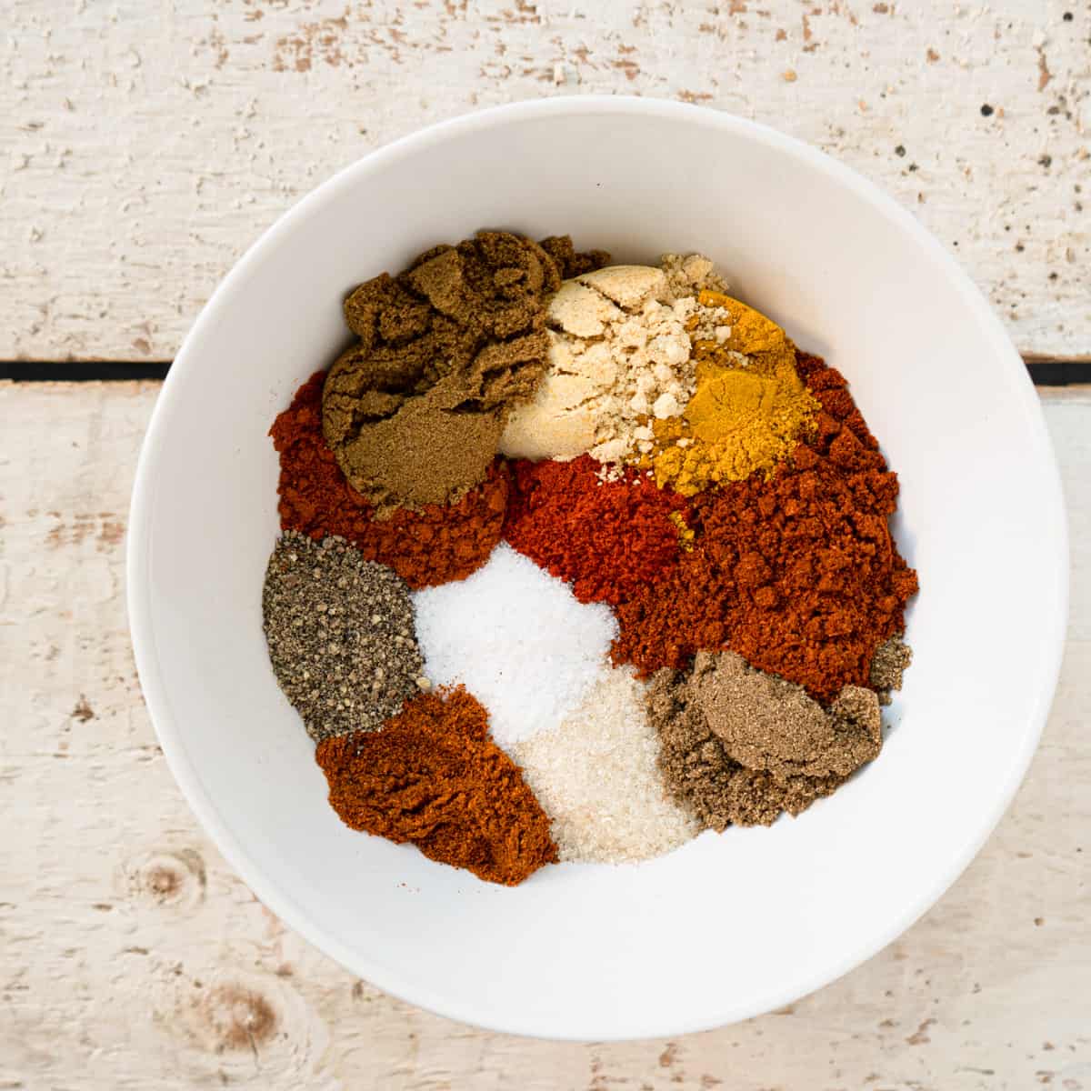 all ingredients to make spice rub in a white bowl.