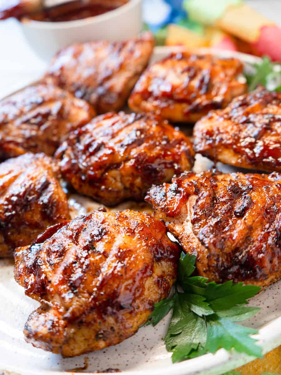 Cooked grilled chicken thighs with parsley garnish.