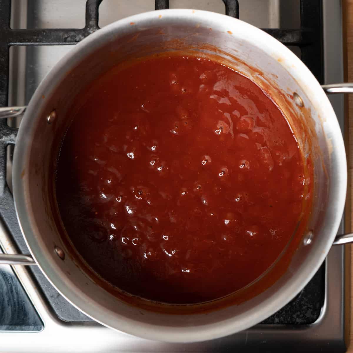 BBQ sauce in a saucepan simmering on the stove. 