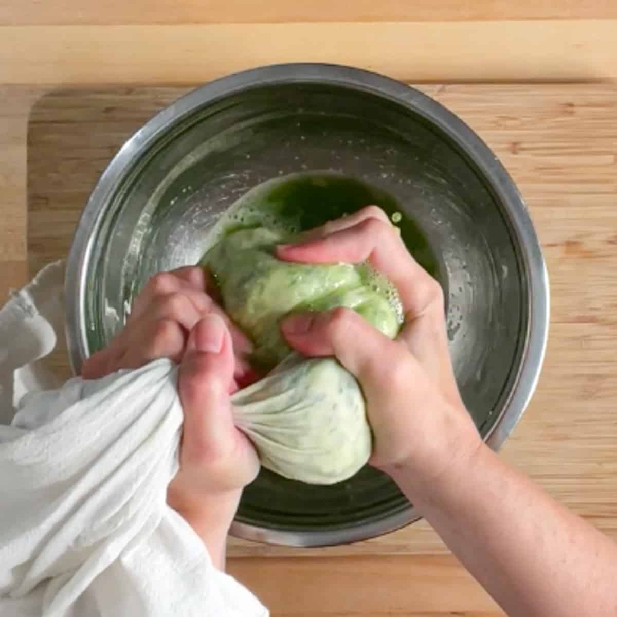 Squeezing liquid out of zucchini inside a cloth.