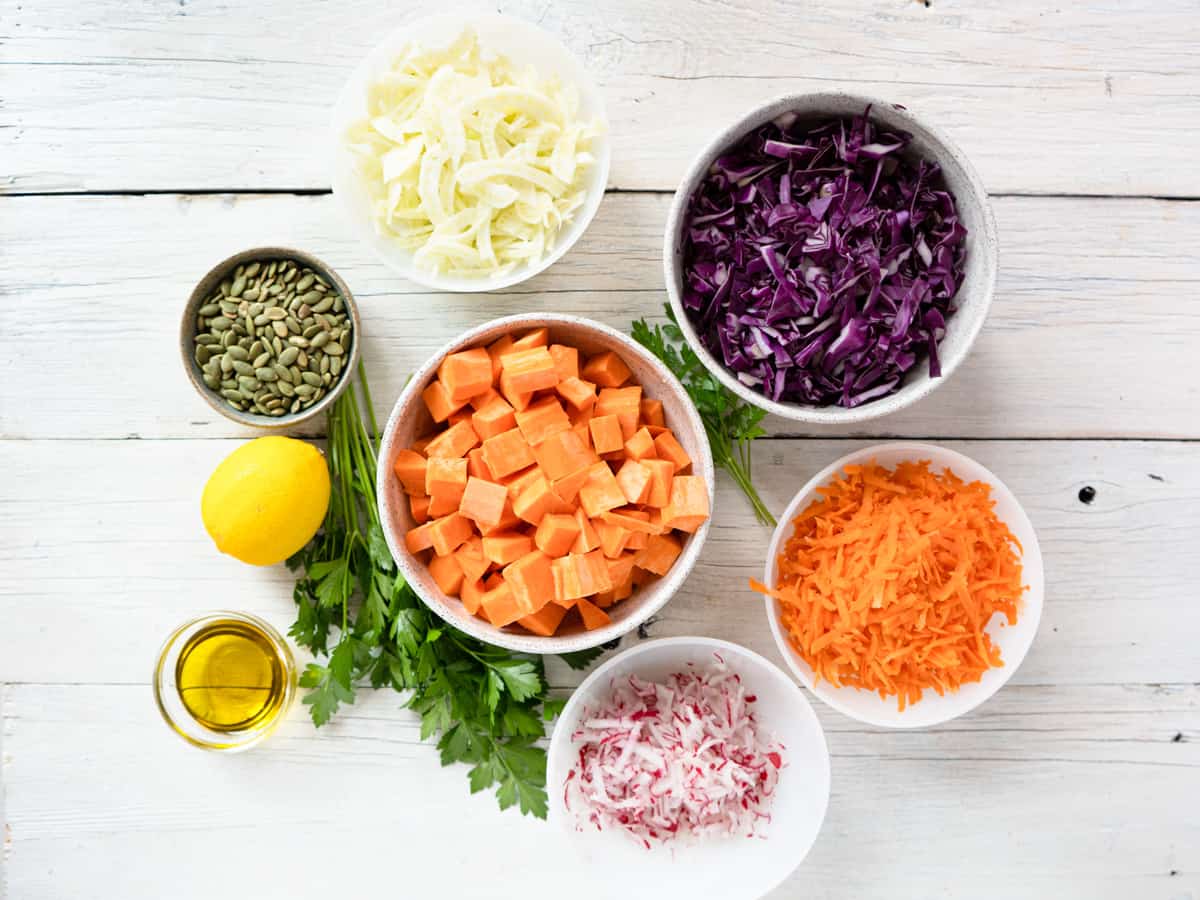 all ingredients to make this salad laid out on a white wood board.